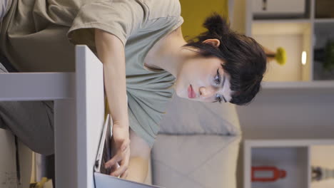 Vertical-video-of-Young-woman-focusing-on-computer-has-serious-expression.
